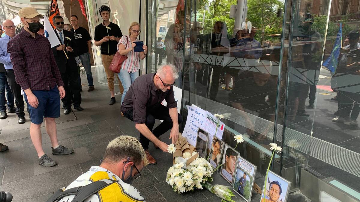 Flowers are laid in front of photos of food delivery drivers, who have been killed over the last two months. Picture: supplied