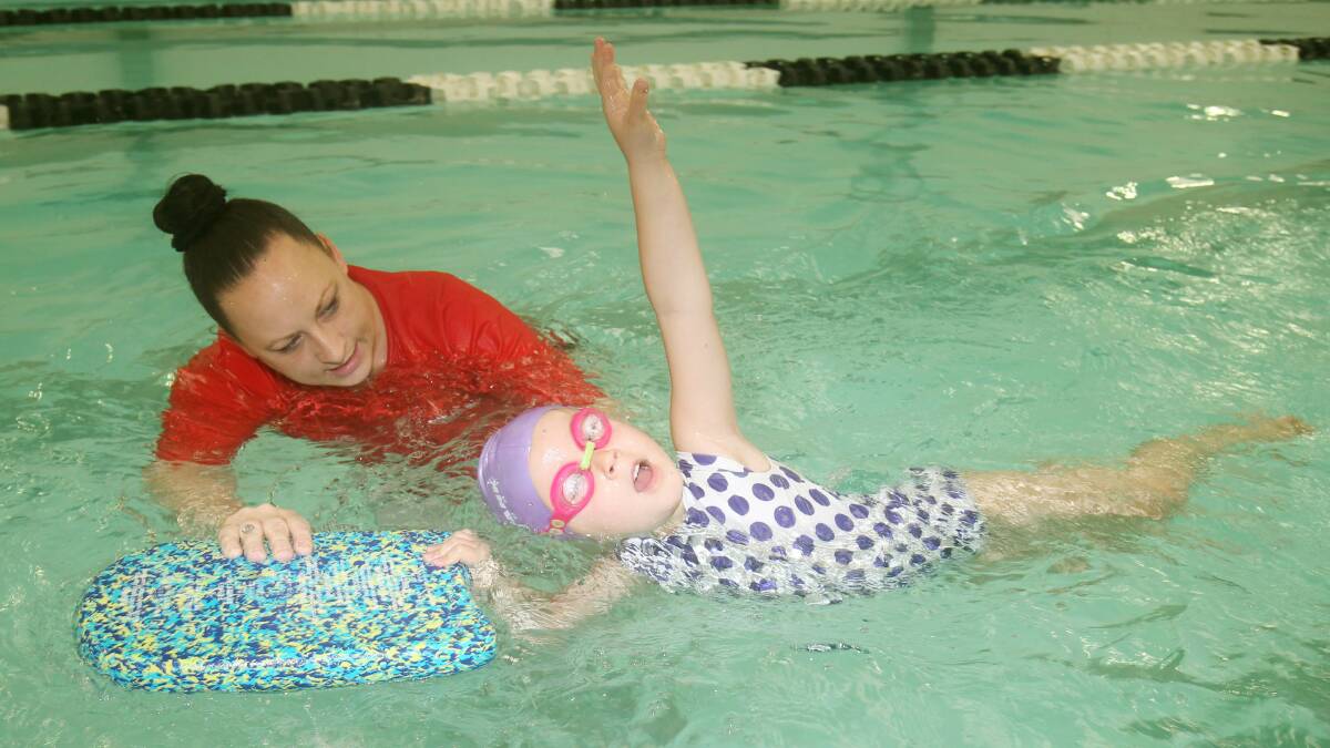 Jade Richey teaches Ava Baxter at Starting Blocks Swim school at Miranda. Picture by Chris Lane