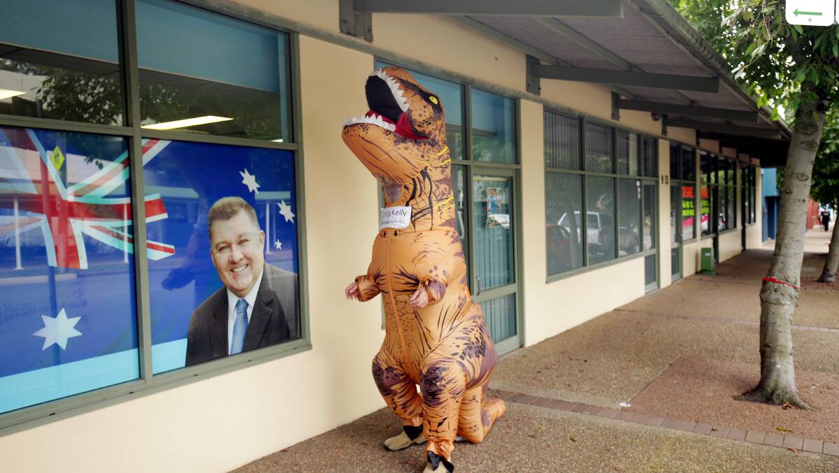 Peter Thompson, wearing the dinosaur outfit, strolls past Craig Kelly's electorate office at Sutherland after the incident. Picture: Chris Lane 