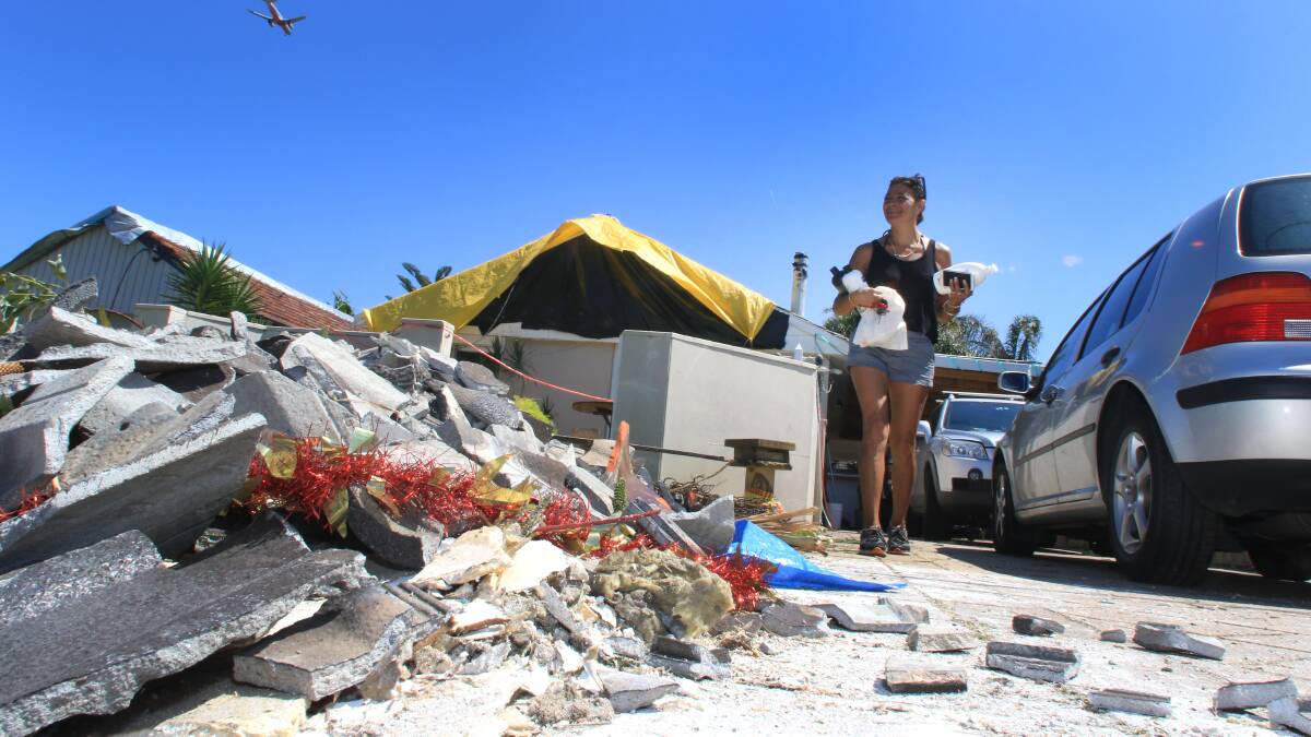 A resident cleans up after the torndado. Picture: Kirk Gilmour