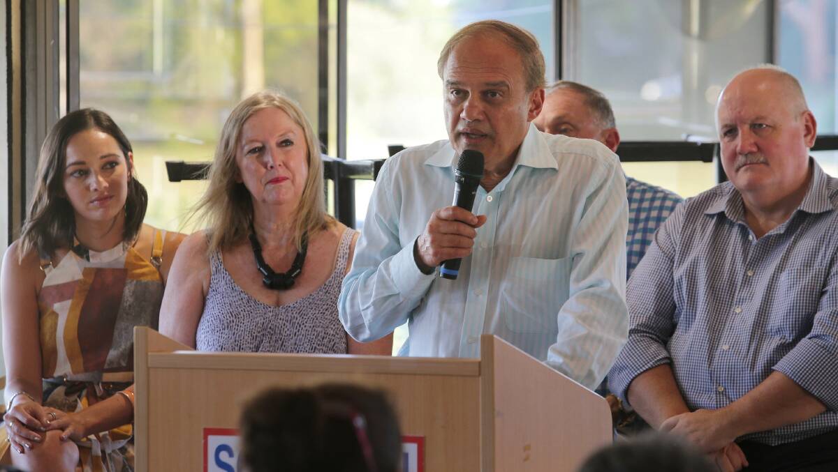 Dr Kiran Phadke addresses the public meeting, watched by his daughter Alana and wife Linda, former Cronulla MP Malcolm Kerr and Heathcote MP Lee Evans. Picture: John Veage