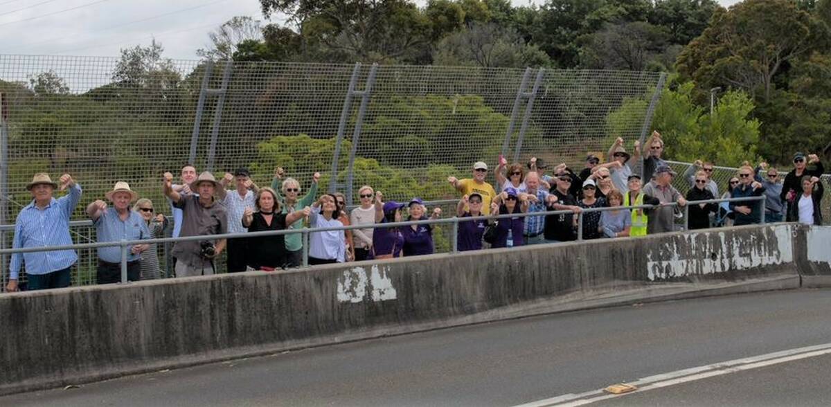 Thumbs down: Protesters vent their anger during a weekend rally on the narrow bridge over the train line at Heathcote East. Picture: David / Michael Oblati