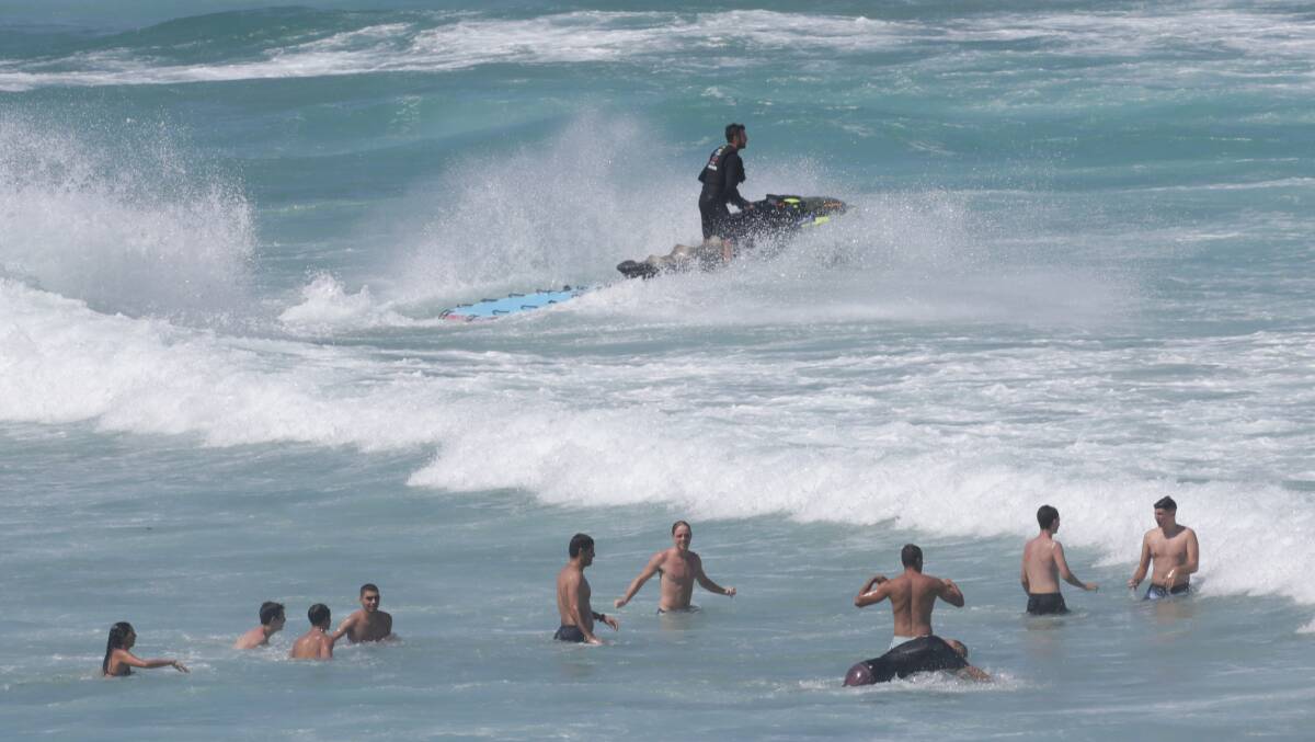 A jet ski rushes to Shelly Beach from Cronulla beach on Saturday after three men got caught in a rip. Picture by John Veage