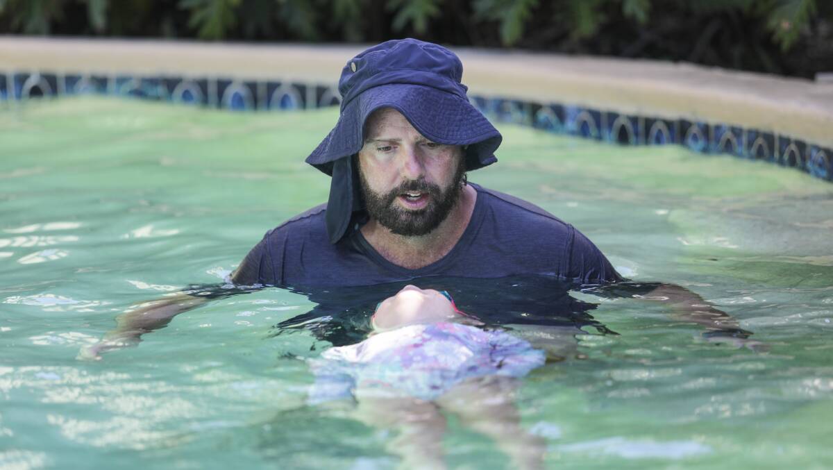 Andrew Duncan teaches a young pupil in his Yarrawarrah home's pool. Picture by John Veage