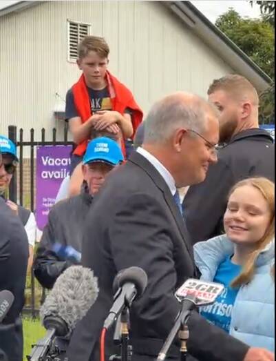 A young boy gets a good view as Scott Morrison receives a smile from daughter Lily at the conclusion of the media conference at the Lilli Pilli Public School polling booth. Picture: Facebook