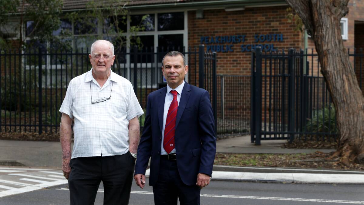 Mark Buttigieg (right) and local resident Phill Edwards outside Peakhurst South Public School, which was without power for several days. Picture: John Veage