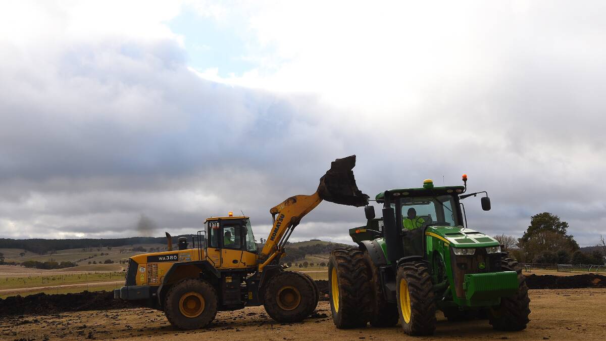 A front end loader moves biosolids to be spread on paddocks on the sheep property Ferndale, NSW.  Photo: Kate Geraghty