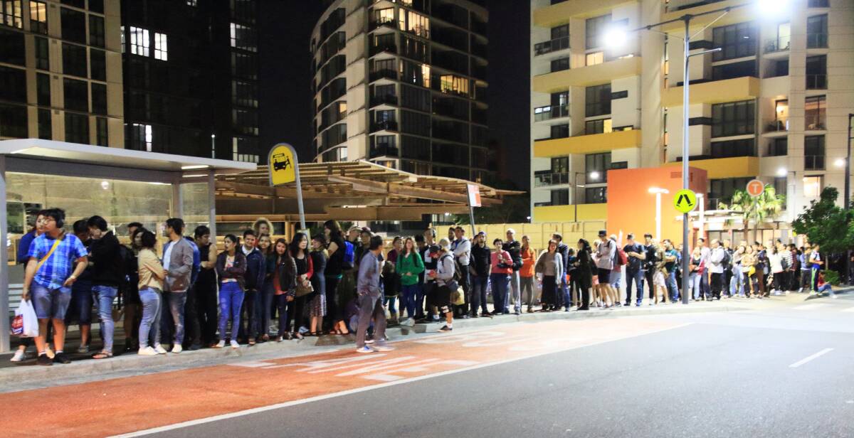 Long wait: a queue of train passengers waiting for a bus to take them from Wolli Creek to Hurstville because of track maintenance. Picture: Joseph Mercieca