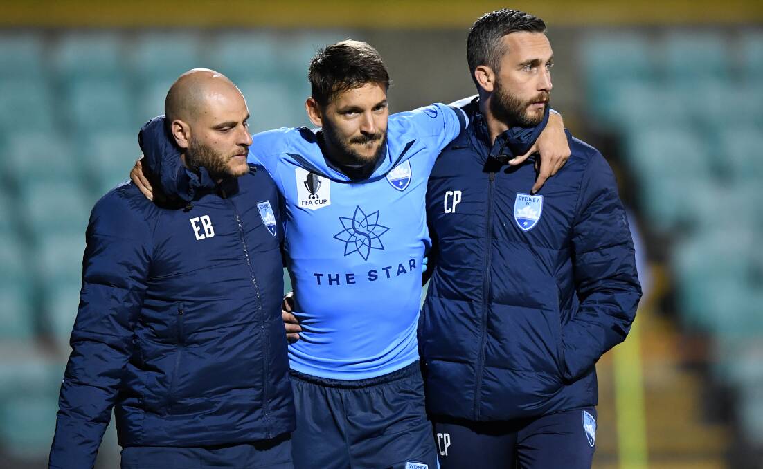 Sydney FC's Milos Ninkovic is assisted off the field after he picked up and injury during the second half of the Sky Blues' loss to the Roar in the FFA Cup last night. Picture: AAP