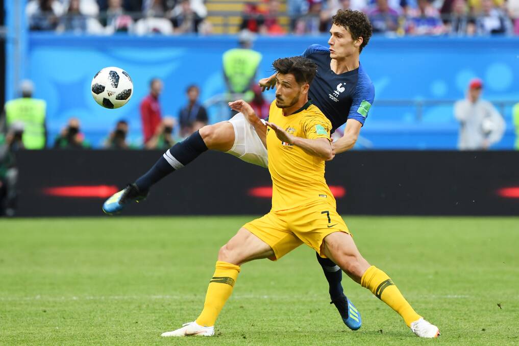 Australia's Mathew Leckie is tackled by Benjamin Pavard of France during their World Cup group match at Kazan Arena. Picture: Dean Lewins, AAP 