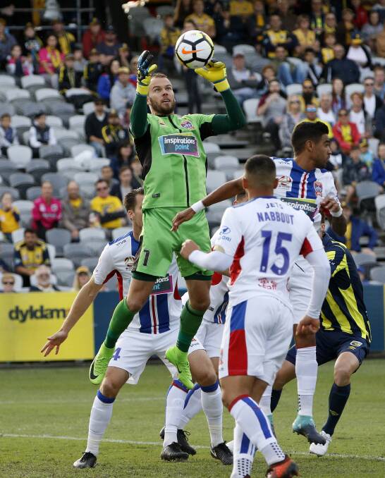 Keeper: Jack Duncan leaps to take a cross during the F3 derby between the Newcastle Jets and Central Coast Mariners.