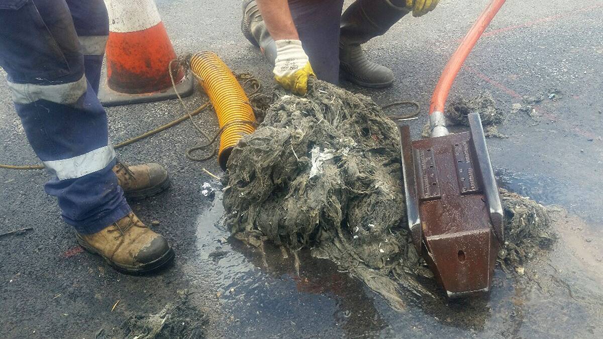 Blocked: Workers clear a wet wipe blockage from wastewater pipes in the Woronora area. Picture: Sydney Water