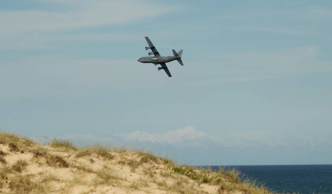 An RAAF C-130J Hercules flying over Bate Bay towards Kurnell yesterday afternoon. Pictures: Chris Lane