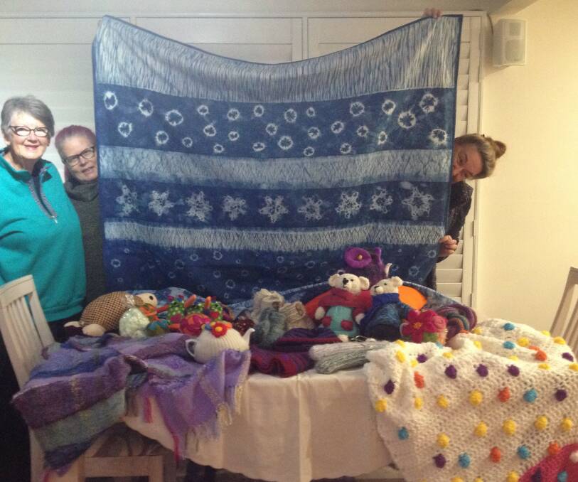 Indigo quilt: (from left) Lynn Christie, Fi Shewring and Chris O'Ryan with the marine-theme quilt which will be raffled for charity. The table shows a selection of items for sale at the festival.