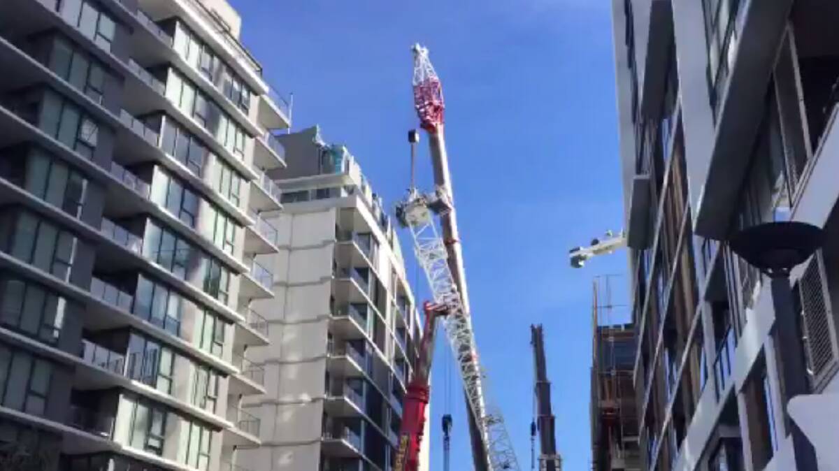 It's off:  A crane which collapsed at a Wolli Creek building site last week is removed from an adjoining building. Pictures: Supplied 