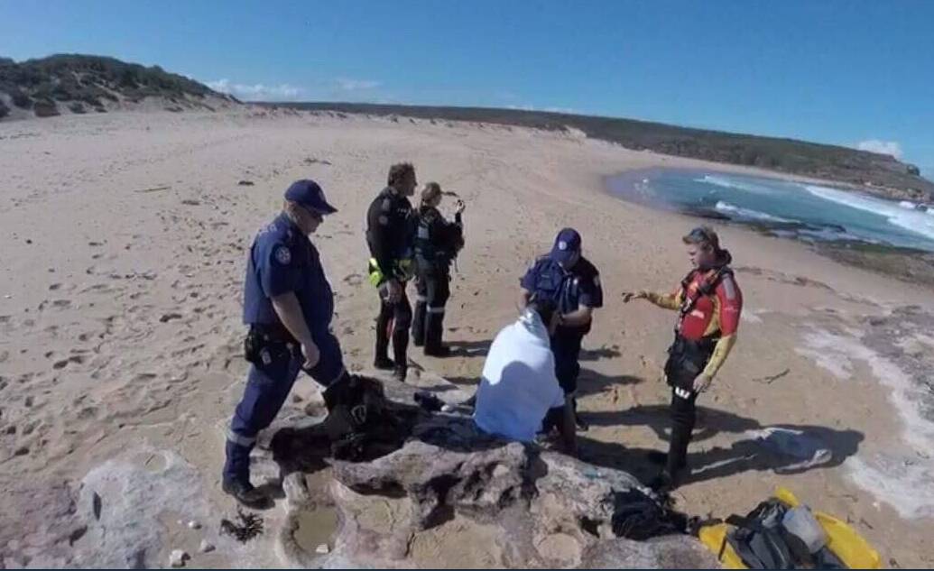 A man is treated on the shore after his boat overturned off Little Marley Beach this afternoon. Pictures: Westpac Rescue Helicopter, 7News