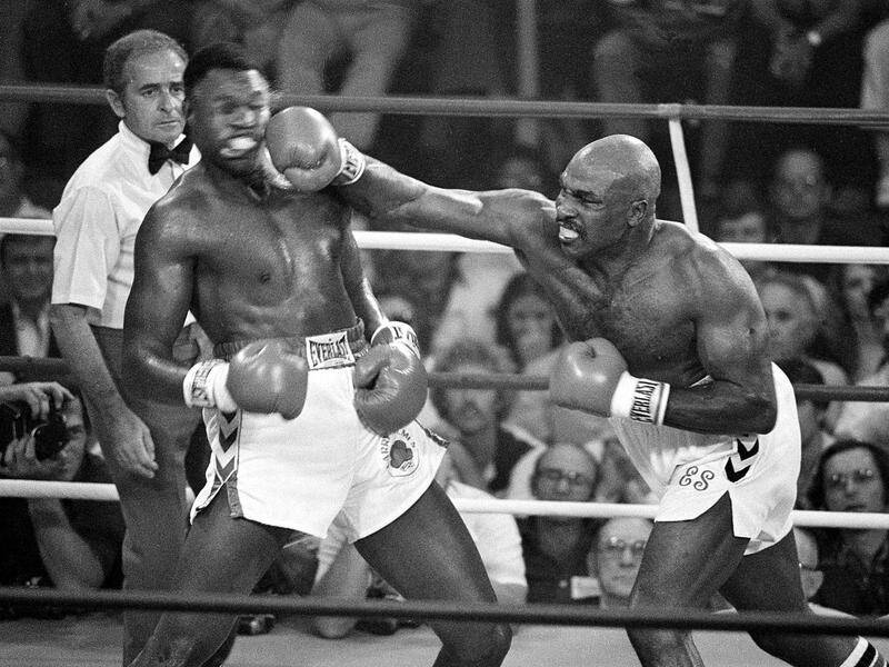 Earnie Shavers drives a right hand to the head of Larry Holmes in 1979. Shavers has died age 78. (AP PHOTO)