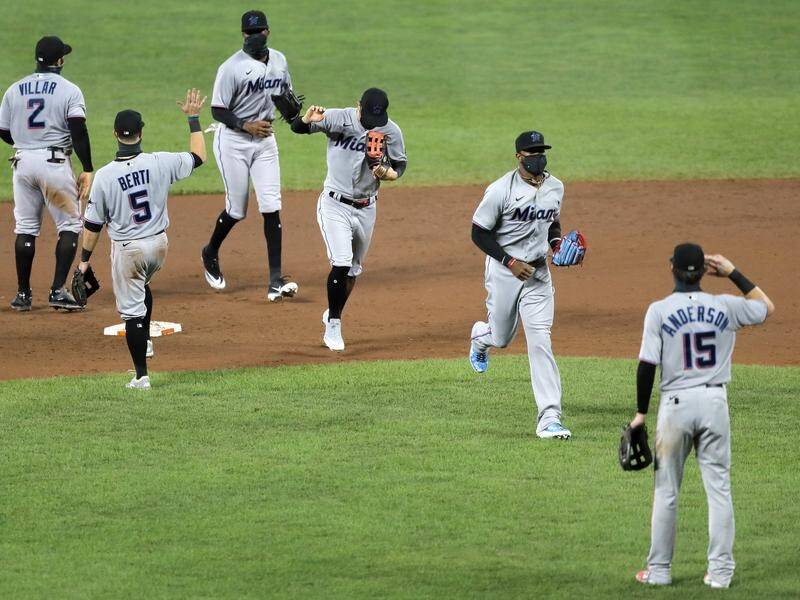 The Miami Marlins engage in socially-distanced celebrations after beating the Orioles.