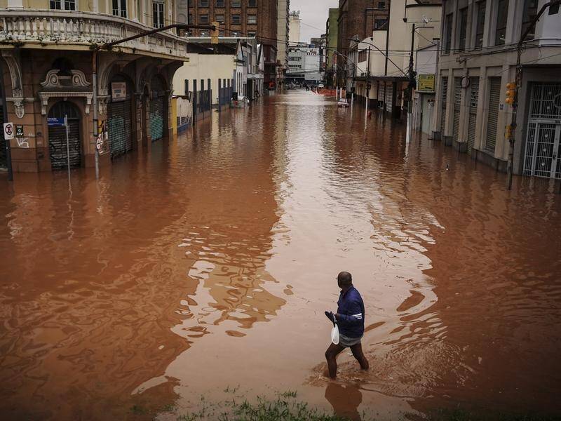 A man wades through an area flooded in Porto Alegre, Rio Grande do Sul state in Brazil. (AP PHOTO)