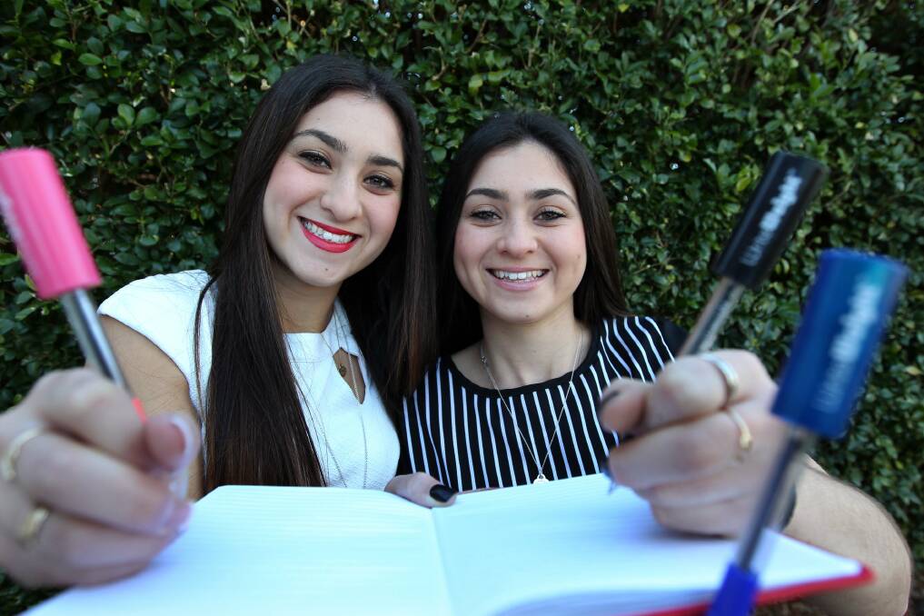 The write stuff: Sisters Cassandra (left) and Jasmine have created a device to help train the hand for long periods of writing. Picture: John Veage