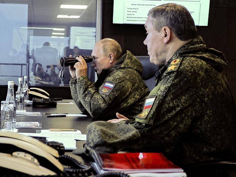 Russian President Vladimir Putin peered through binoculars while seated next to Valery Gerasimov. (AP PHOTO)