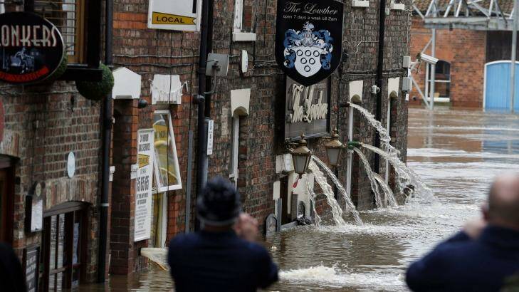 Flood water is pumped out of pubs, after flooding, in York, England on Monday. Photo: PA
