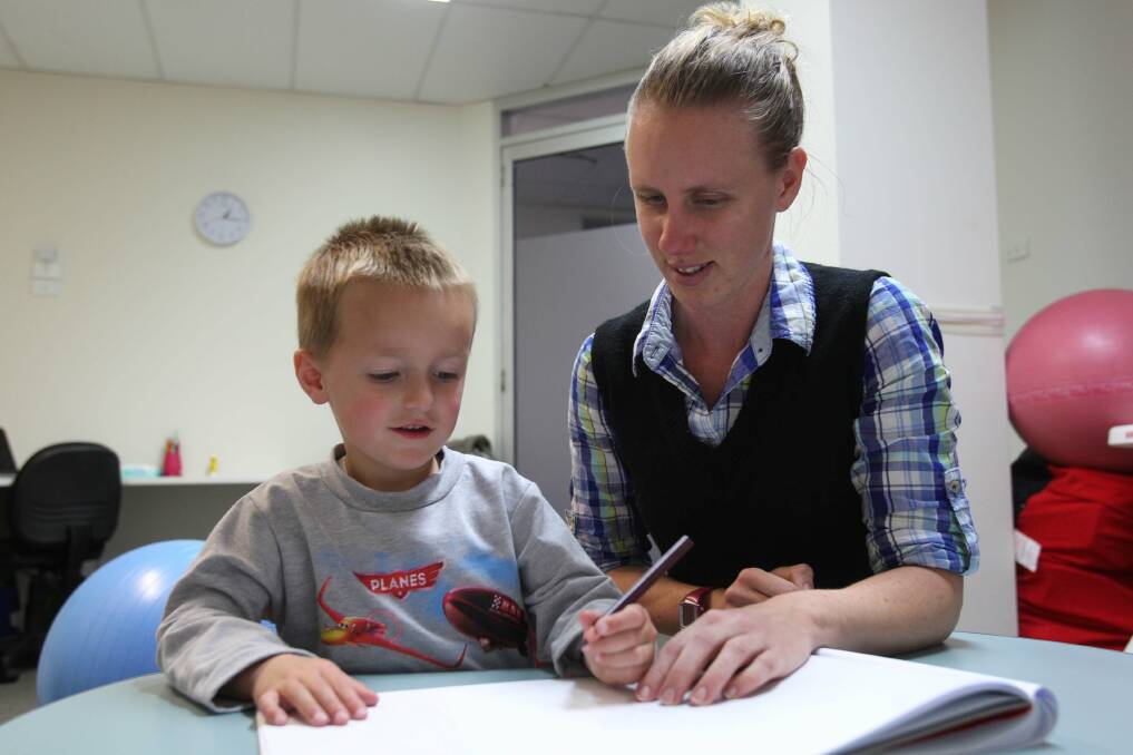 The write stuff: Jacky Peile makes sure kids like Alex Efthimiou can hold their pen properly. Picture: Chris Lane