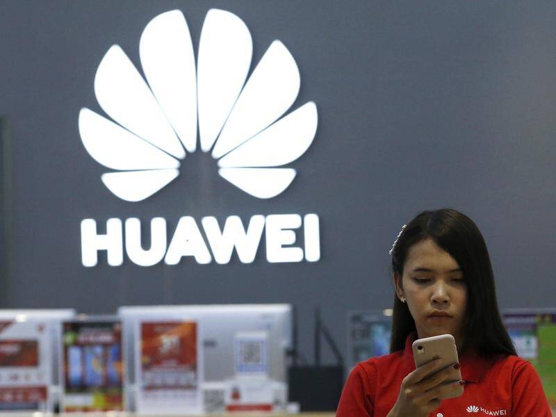 A Thai employee checks a Huawei smartphone at a Huawei store in Bangkok, Thailand.