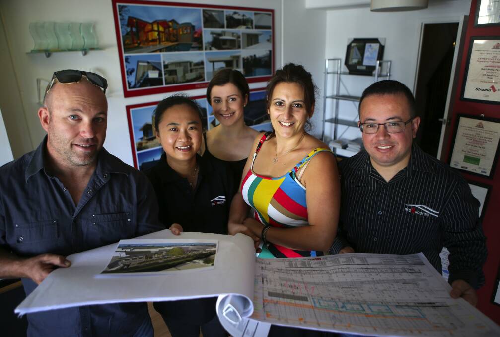 Shire creation: Jason Cavanagh and staff, Fay Xu, Maria Simpson, Bernice Lethlean and Diego Riano with designs for the "fish scales" facade of Westfield Miranda, which Red 8 Roofing brought to reality. Picture: John Veage