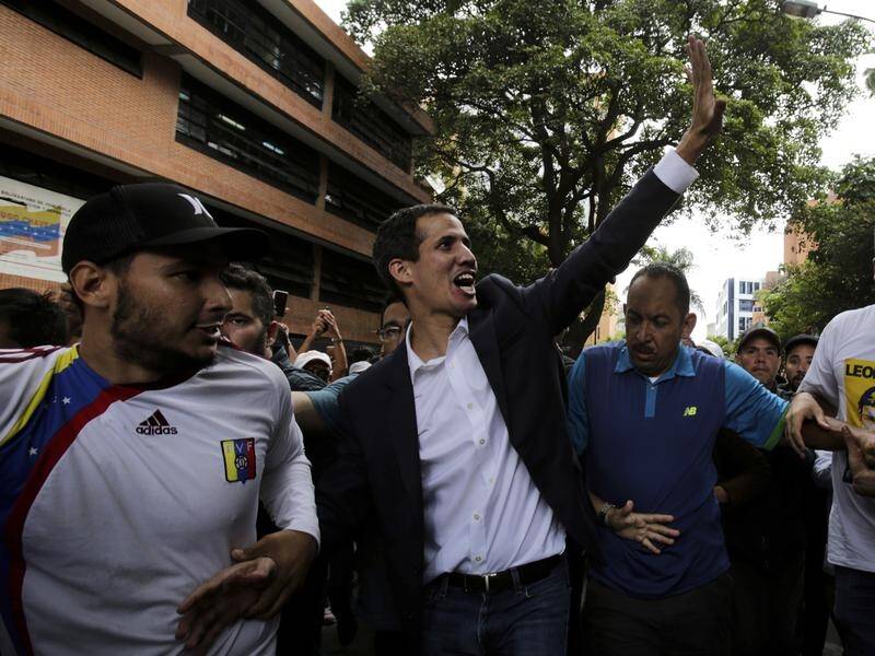 Venezuela opposition leader Juan Guaido (waving) has said he is willing to replace the president.