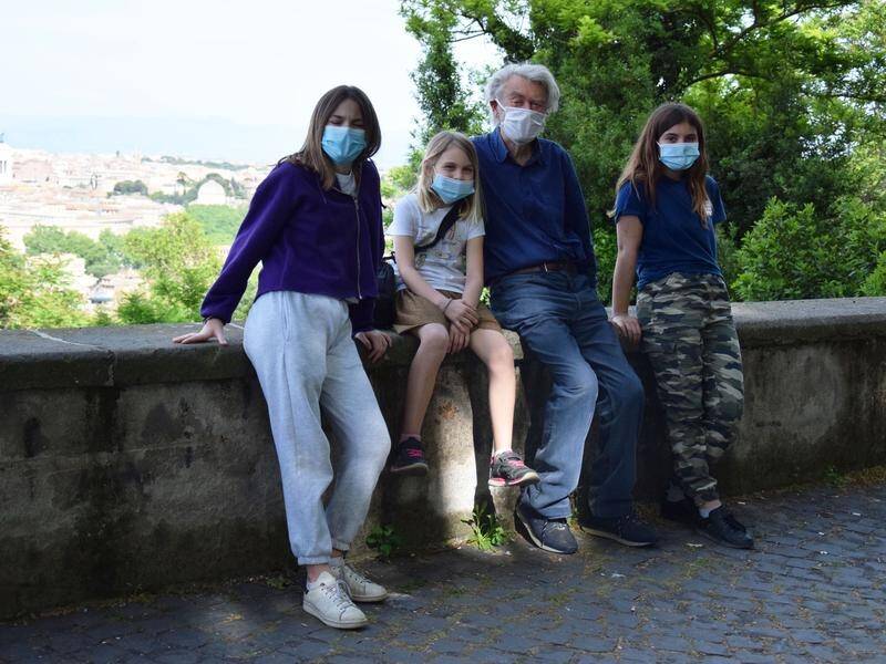 Australian writer Desmond O'Grady, 90, with his granddaughters in Rome as a virus lockdown is eased.