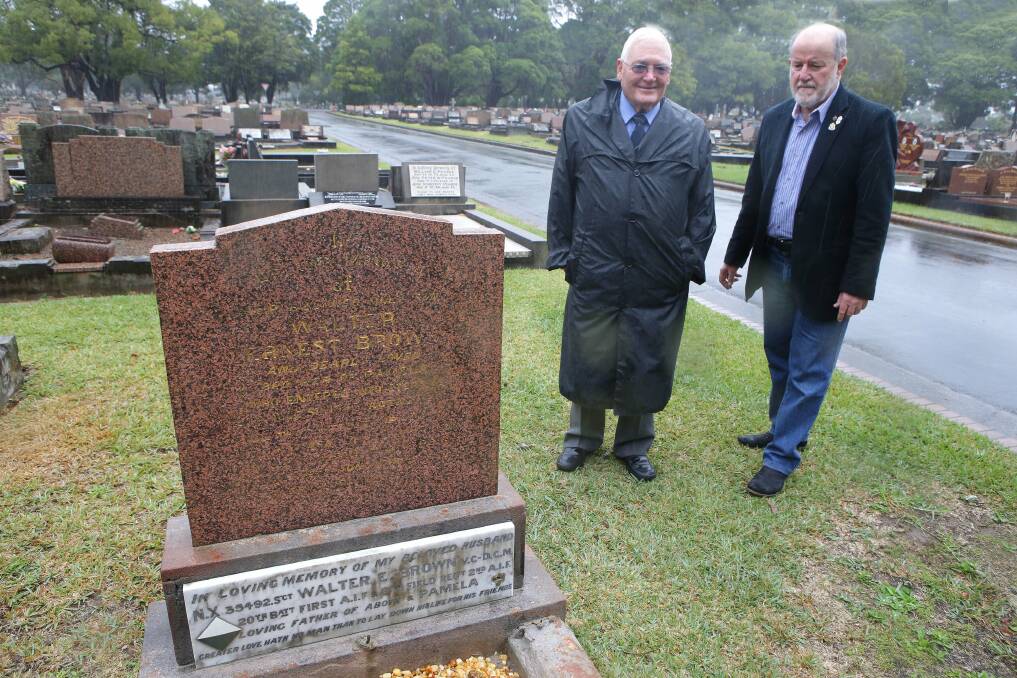 Lest we forget: Legacy members Bruce Hancock and Stan Mackie at the grave of seven-year-old Ernest Brown at Woronora Cemetery which contains the memorial to his father, WWI VC winner and WWII hero Walter Brown. Picture: John Veage