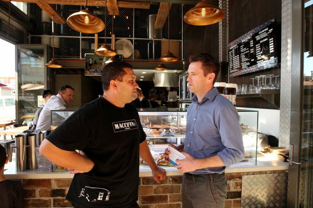Campaign trail: Labor candidate for Kogarah Chris Minns campaigns at Kingsgrove and talks to cafe owner Harry Ambanavos. Picture: Chris Lane