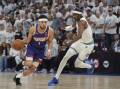 Suns guard Devin Booker (1) drives against Timberwolves forward Jaden McDaniels. (AP PHOTO)