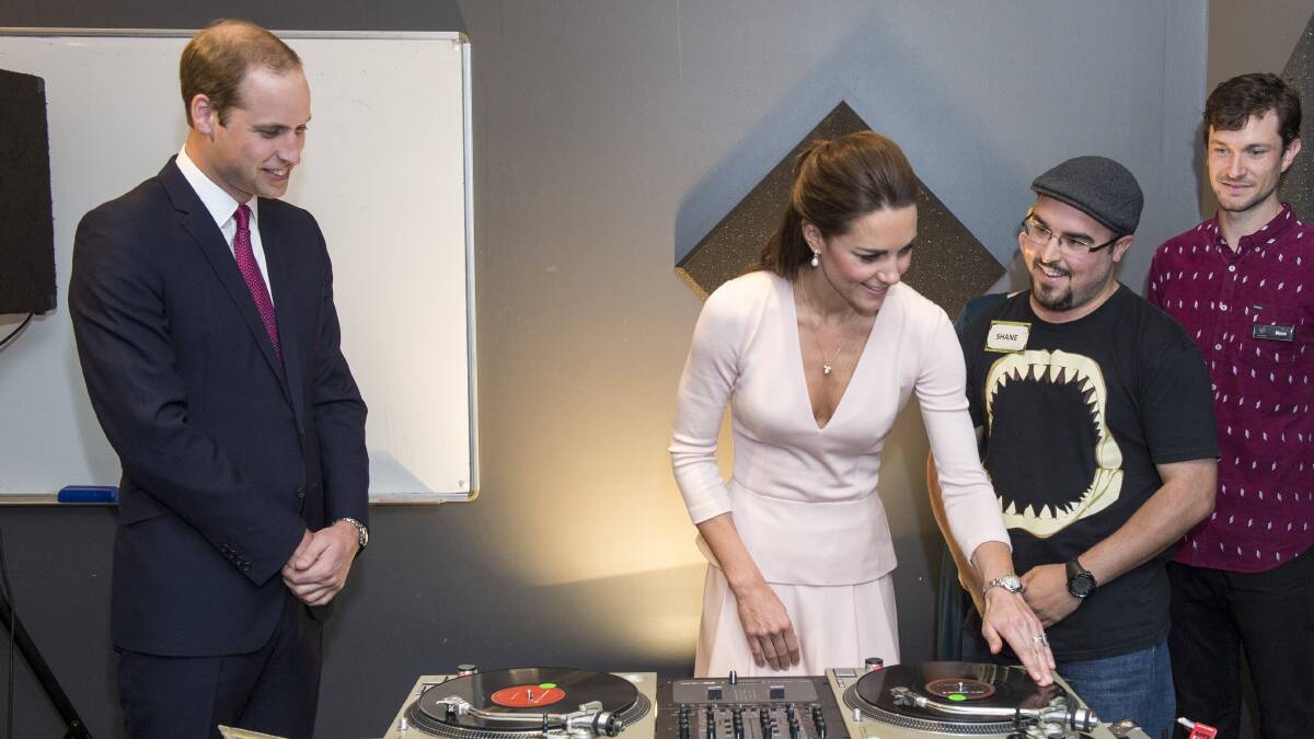 Prince William, Duke of Cambridge looks on as Catherine, Duchess of Cambridge is shown how to play on turntable decks at the youth community centre, The Northern Sound System in Elizabeth, Adelaide on April 23, 2014. Picture: Getty Images. 