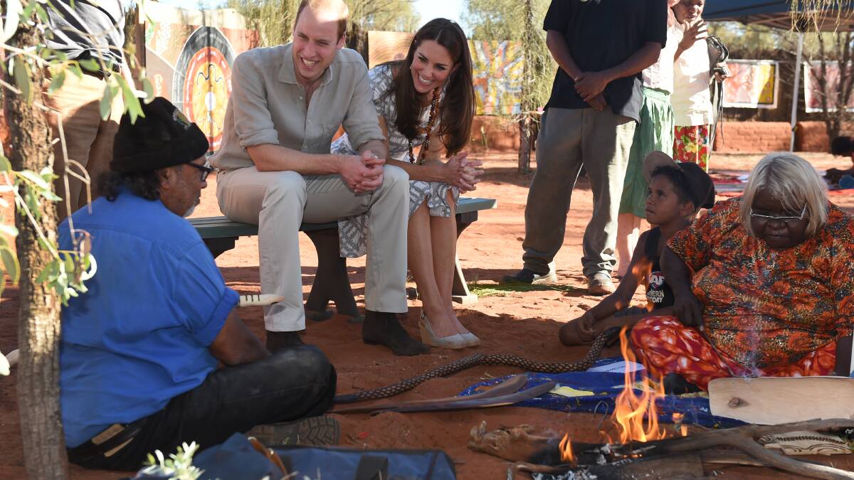 Prince William, Duke of Cambridge and Catherine, Duchess of Cambridge inspect a wooden snake made by Aboriginal elders during a visit to Uluru-Kata Tjuta Cultural Centre at Uluru on April 22. Picture: Getty Images.