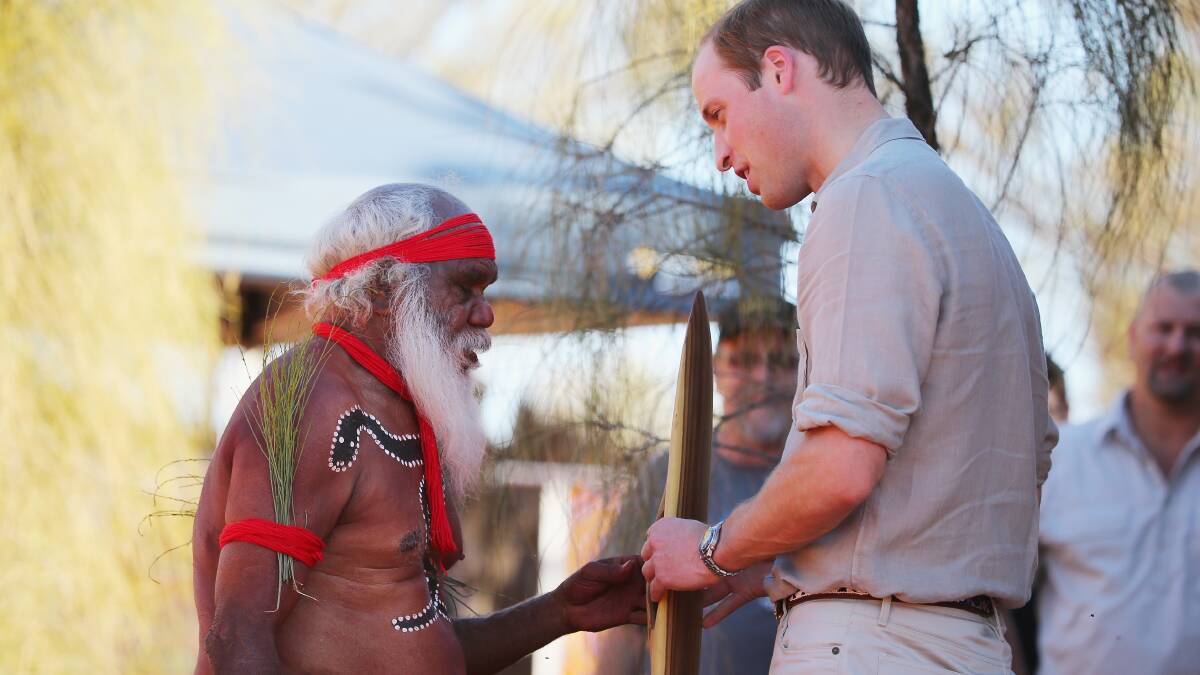 Prince William, Duke of Cambridge is presented with a gift by an Aboriginal man as they arrive at the Cultural Centre, Uluru-Kata Tjuta National Park on April 22. Picture: Getty Images.