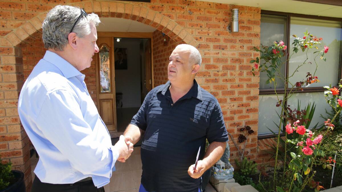 New territory: Greg Holland talks with Sam Wahhab while door-knocking at Alfords Point. Picture: Chris Lane
