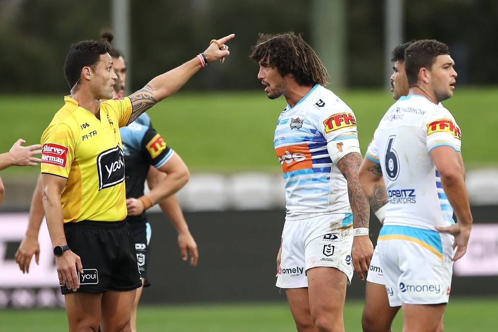 Titans' Kevin Proctor is sent off by referee Henry Perenara for biting the forearm of Shaun Johnson of the Sharks. Photo: Mark Kolbe/Getty Images
