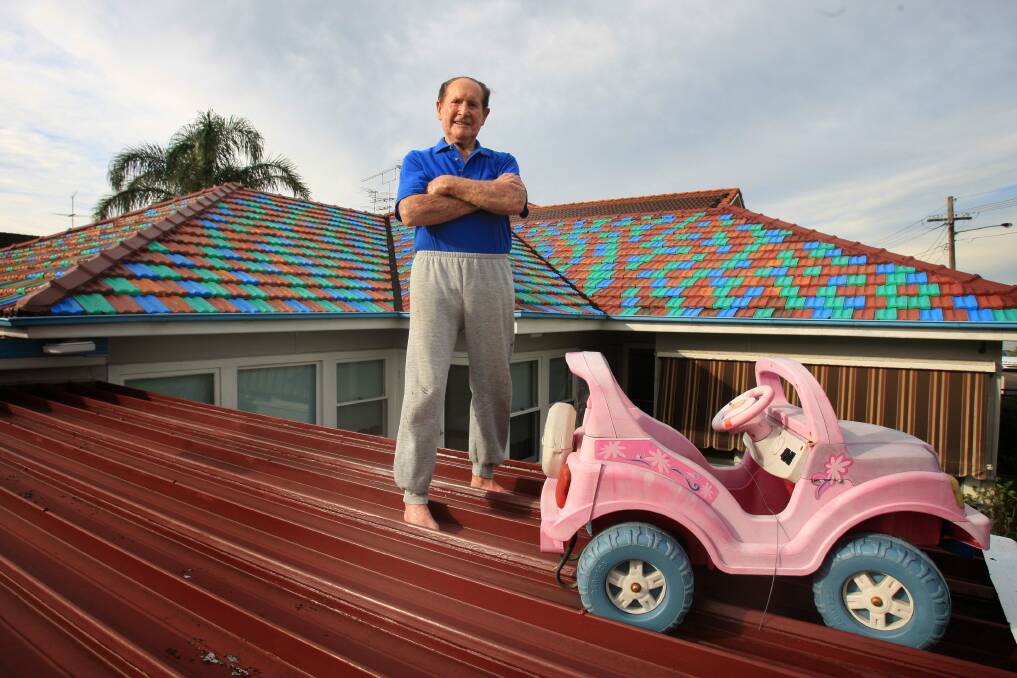 John Hall, who painted the roof tiles on his Sans Souci house so his so his late wife Berta could "see it better from heaven", has  improved the view by adding some toy cars. Picture: james Alcock
