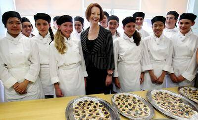 Food for thought: Prime Minister Julia Gillard with food technology students who prepared afternoon tea for the education forum at the Penshurst college. Left: Ms Gillard presents an Australian flag which hung in Parliament on the first sitting day this year to Anne Ross, principal of Georges River College, Penshurst campus. Pictures: Jane Dyson 