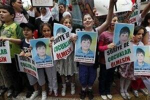 Face of the revolution: Syrian children carry pictures of 13-year-old Hamza.