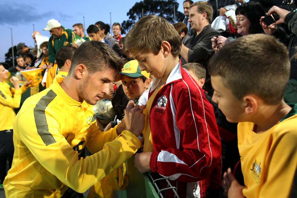Solid fan base:  Socceroos captain Lucas Neill signs autographs before a training session at WIN Jubilee Oval, Kogarah.  Picture: Jane Dyson