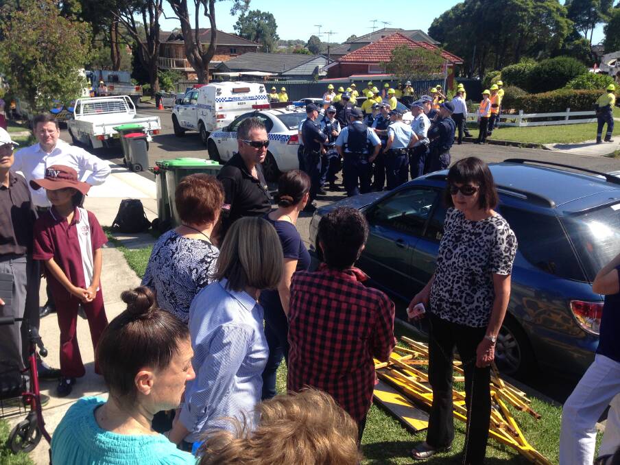 Stand-off: Residents, police and Ausgrid workers at the site Tuesday morning. Picture: Jane Dyson