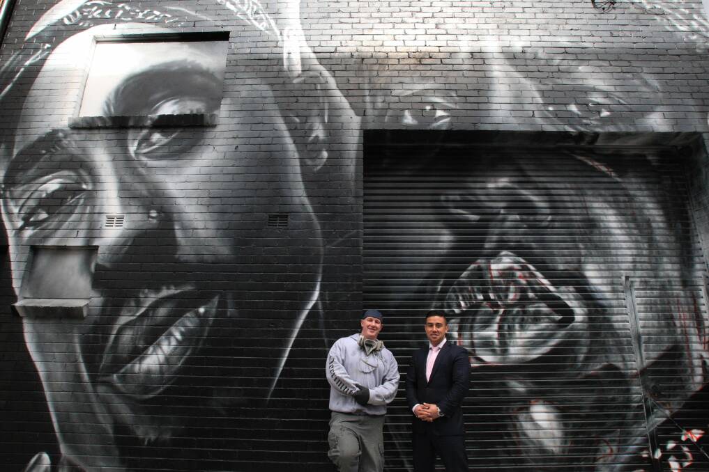 Street life: Artist Mark Taylor (left) with Telstra’s Chris Chan in front of the mural. Pictures: Chris Lane